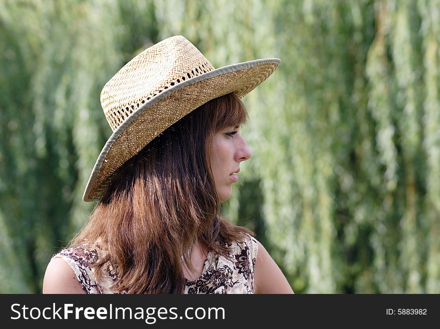 Beautiful woman in the strow hat. Looks like a cowgirl. A half face