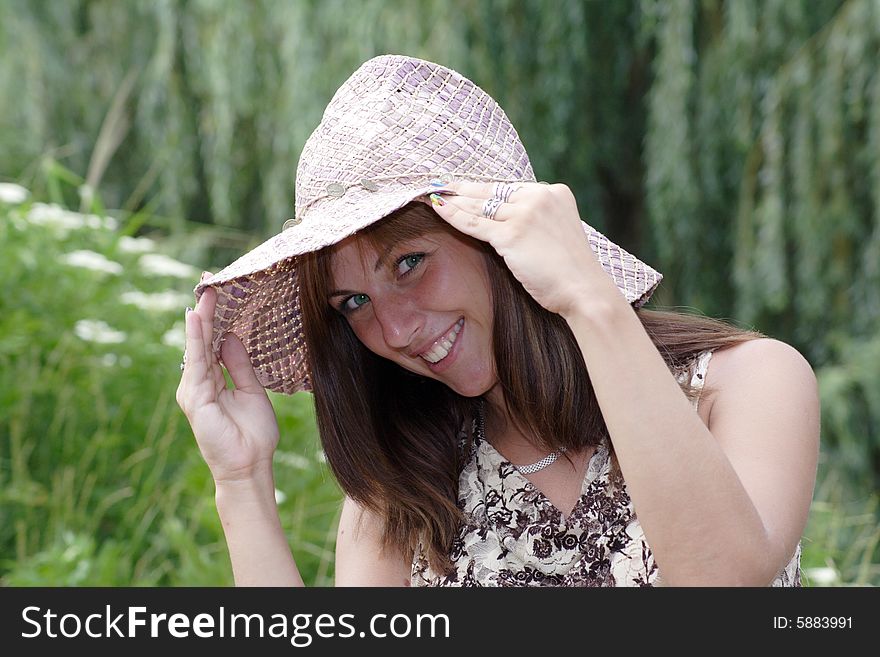 Beautiful woman in vintage hat look out from under hat's brim with a coquettish smile. Beautiful woman in vintage hat look out from under hat's brim with a coquettish smile