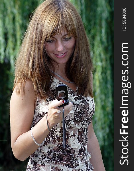 Young beautiful woman with chestnut-coloured hair typing sms message. Young beautiful woman with chestnut-coloured hair typing sms message