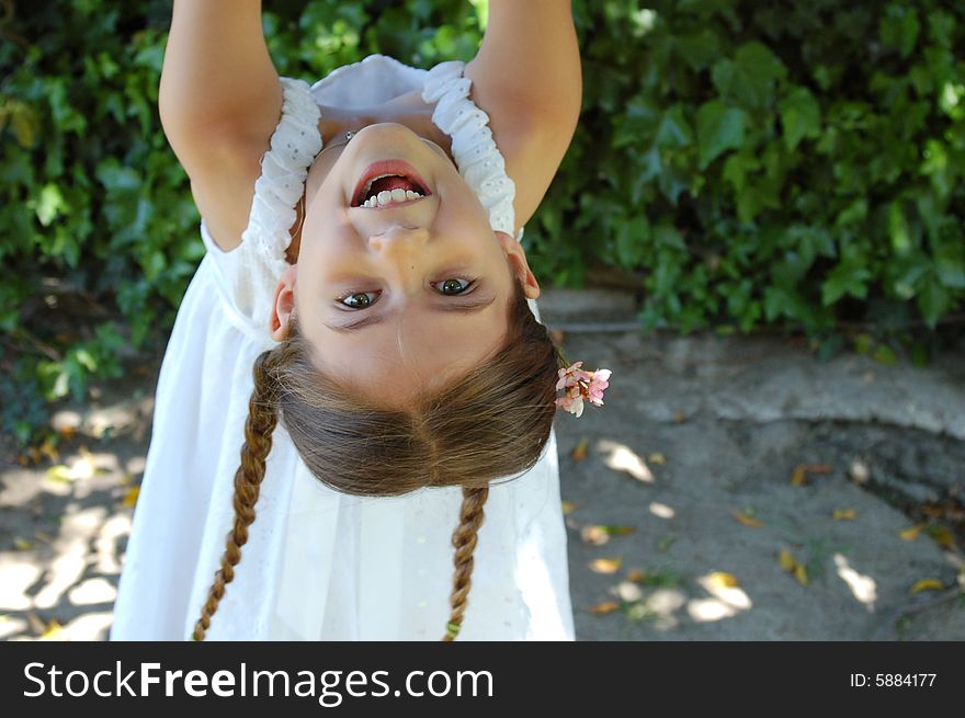 A girl with pigtails hangs from a tree. A girl with pigtails hangs from a tree