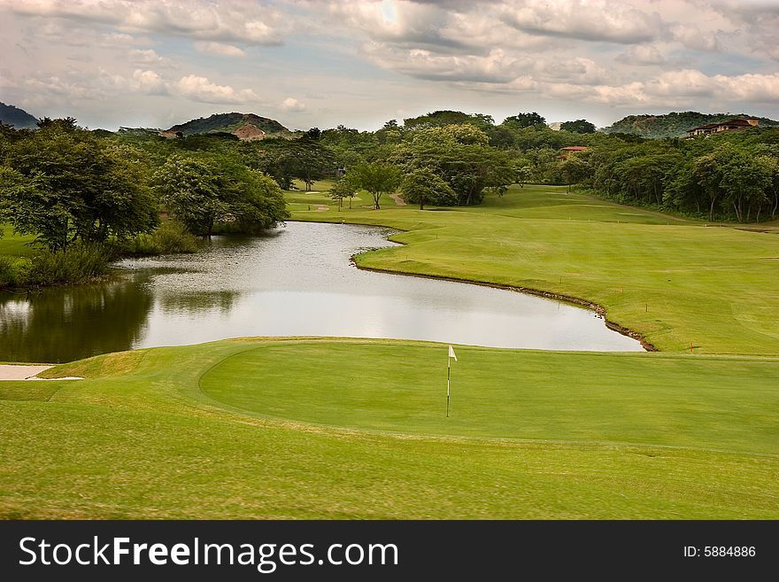 A golf course and lake under stormy skies. A golf course and lake under stormy skies
