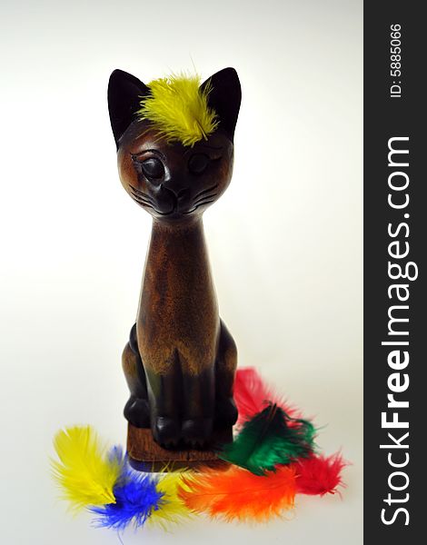 Wooden Cat and Colourful Feathers on white background