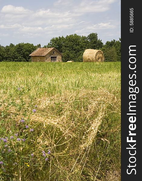 Small cottage in a French field next to a large haystack. Small cottage in a French field next to a large haystack