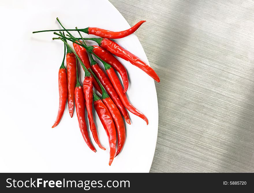 Peppers arranged on edge of white plate. Peppers arranged on edge of white plate