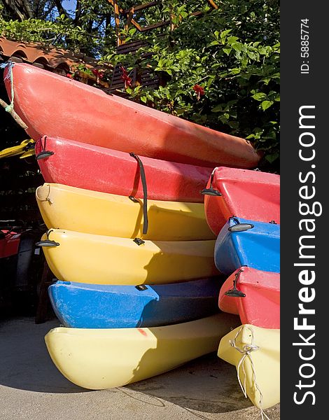 Stacks of red yellow and blue kayaks. Stacks of red yellow and blue kayaks