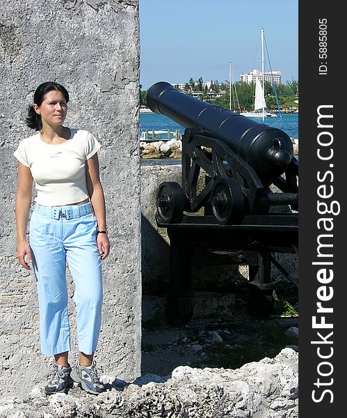 The girl standing on a wall next to the canon of historical XVIII century Montagu fort in Nassau, the capital of The Bahamas. The girl standing on a wall next to the canon of historical XVIII century Montagu fort in Nassau, the capital of The Bahamas.