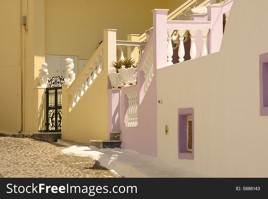 Traditional old Greek pastel painted stucco staircases in Santorini. Traditional old Greek pastel painted stucco staircases in Santorini