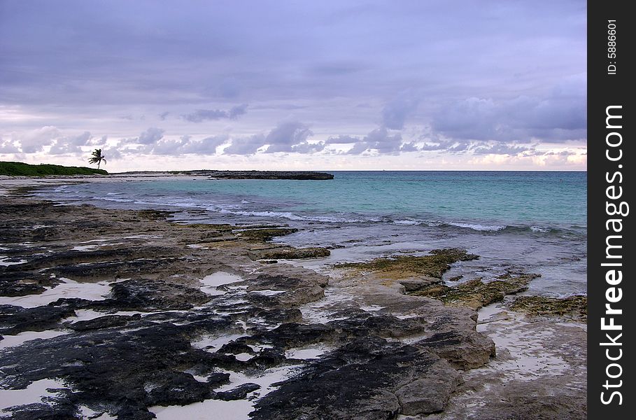 The rocky coast on Paradise Island with dark cloudy sky in a background (The Bahamas). The rocky coast on Paradise Island with dark cloudy sky in a background (The Bahamas).