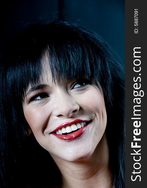 Head and bare shoulders of a young lady with black hair and red lipstick smiling. Head and bare shoulders of a young lady with black hair and red lipstick smiling.