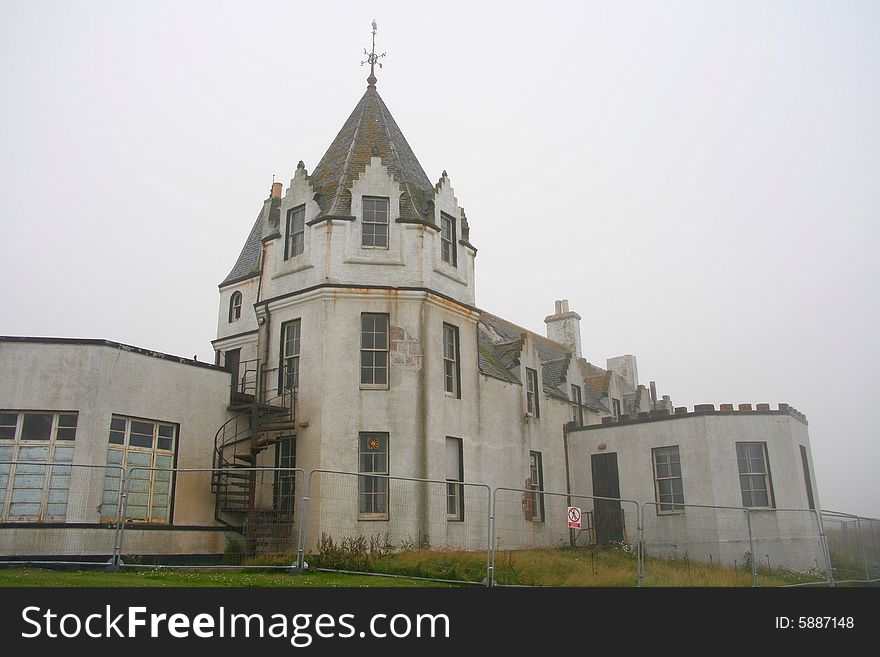 An old hotel abandoned and fenced off.
