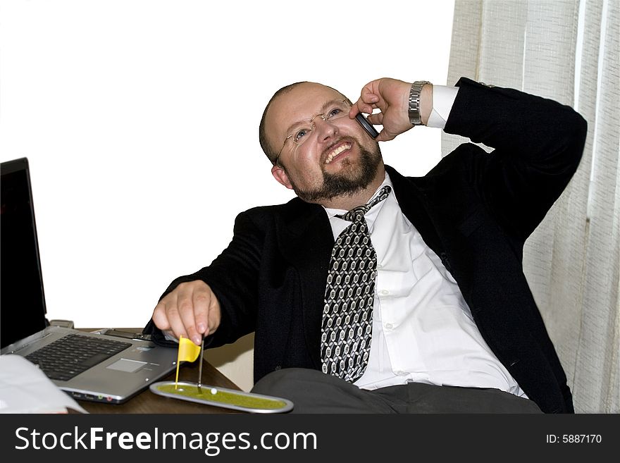 Smiling businessman in the office talking over the phone. Smiling businessman in the office talking over the phone