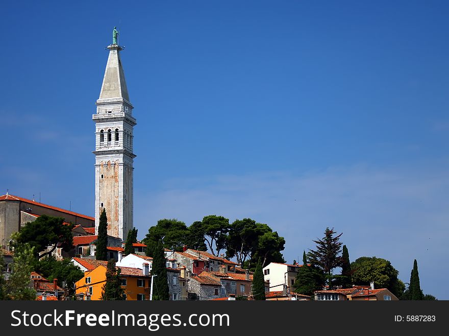 Houses and church tower by the sea in the town on the Adriatic coast in Croatia. Houses and church tower by the sea in the town on the Adriatic coast in Croatia.