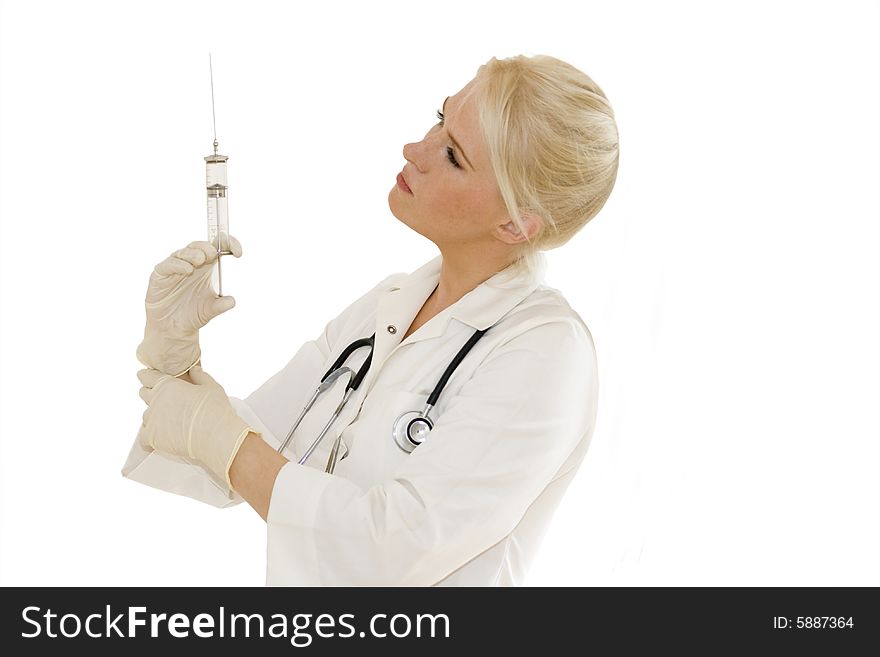 A young female doctor/nurse with gloves looks at syringe  isolated on white background. A young female doctor/nurse with gloves looks at syringe  isolated on white background