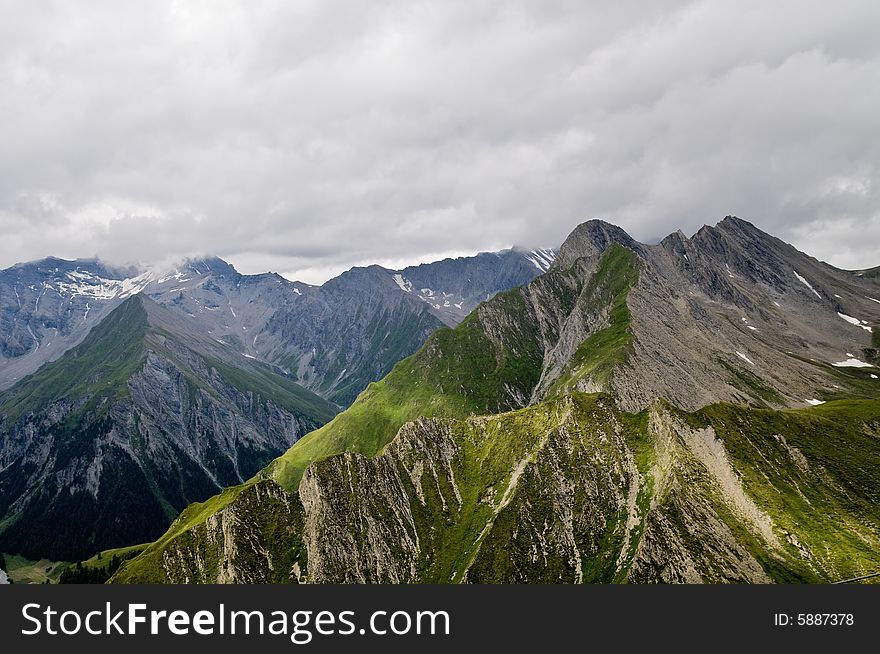 Dramatic weather change. Scenic view of storm clouds over Swiss Alps mountains near Samnaun, Graubunden Canton, Switzerland. Dramatic weather change. Scenic view of storm clouds over Swiss Alps mountains near Samnaun, Graubunden Canton, Switzerland.