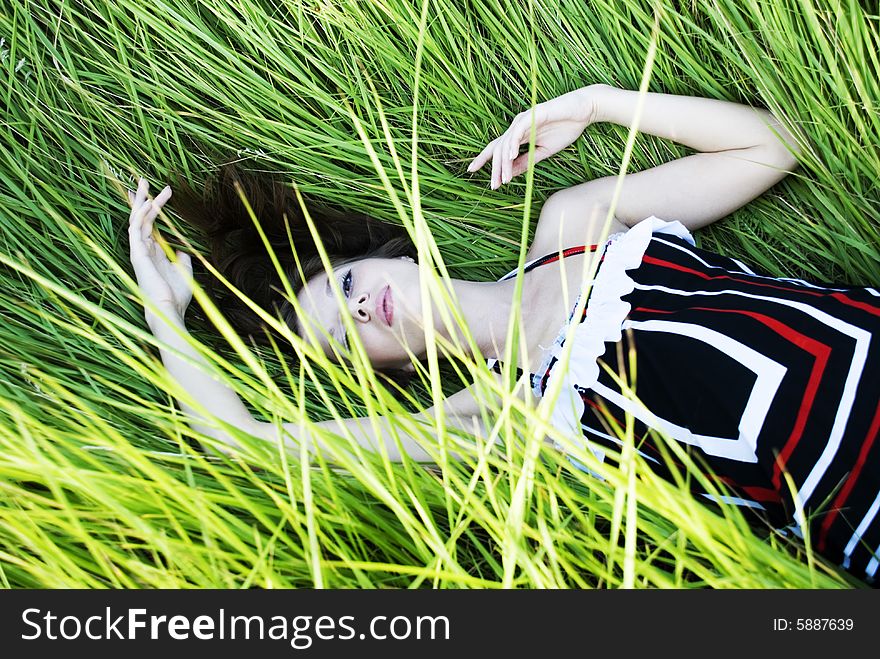 Beauty young woman lying in green fresh grass. Beauty young woman lying in green fresh grass