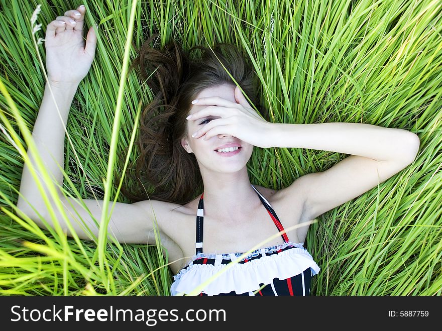 Beauty young woman lying in green fresh grass. Beauty young woman lying in green fresh grass