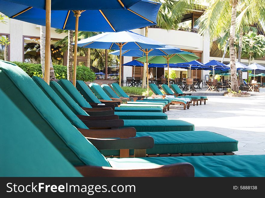 Row of chairs beside swimming pool si at beach resort. Row of chairs beside swimming pool si at beach resort