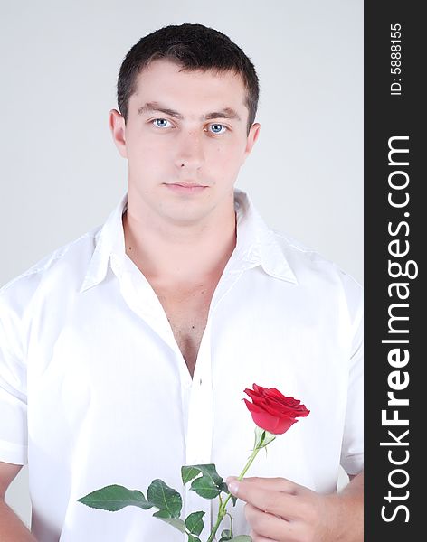 Young athlete man with red rose in hand isolated at white background. Young athlete man with red rose in hand isolated at white background