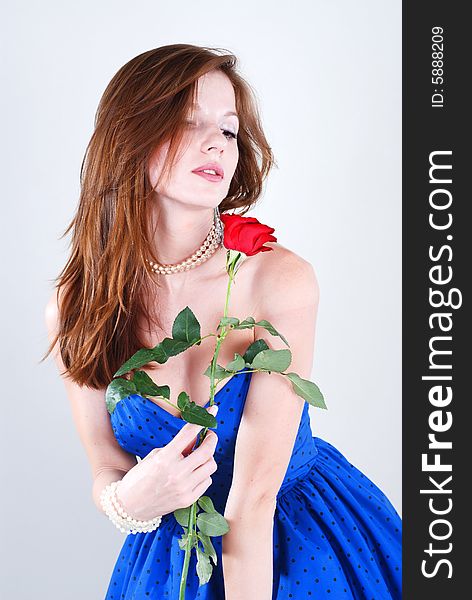 Beauty young woman in blue dress with rose at white isolated background