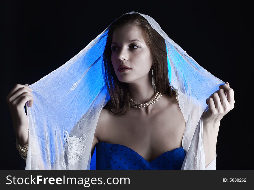 Beauty young woman in blue dress at black background