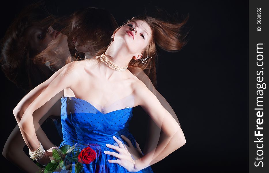 Beauty young woman in blue dress with rose at black background. Beauty young woman in blue dress with rose at black background