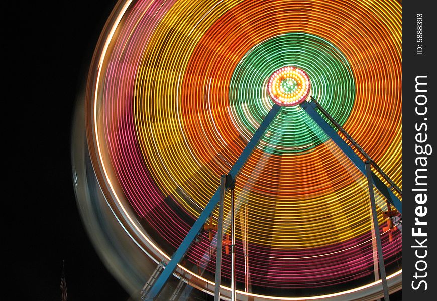 Ferris wheel at night, long exposure creating a blur effect