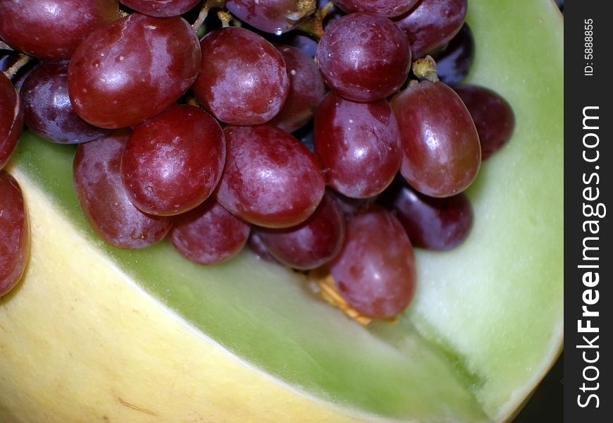 Juicy red grapes atop of a honeydew melon. Juicy red grapes atop of a honeydew melon.