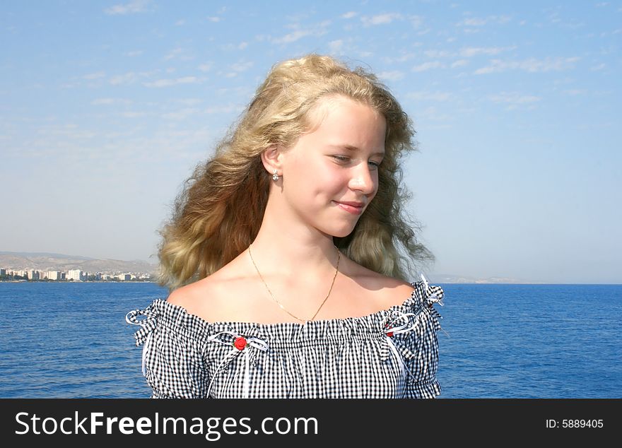 Pretty blond girl with long hair at the sea.