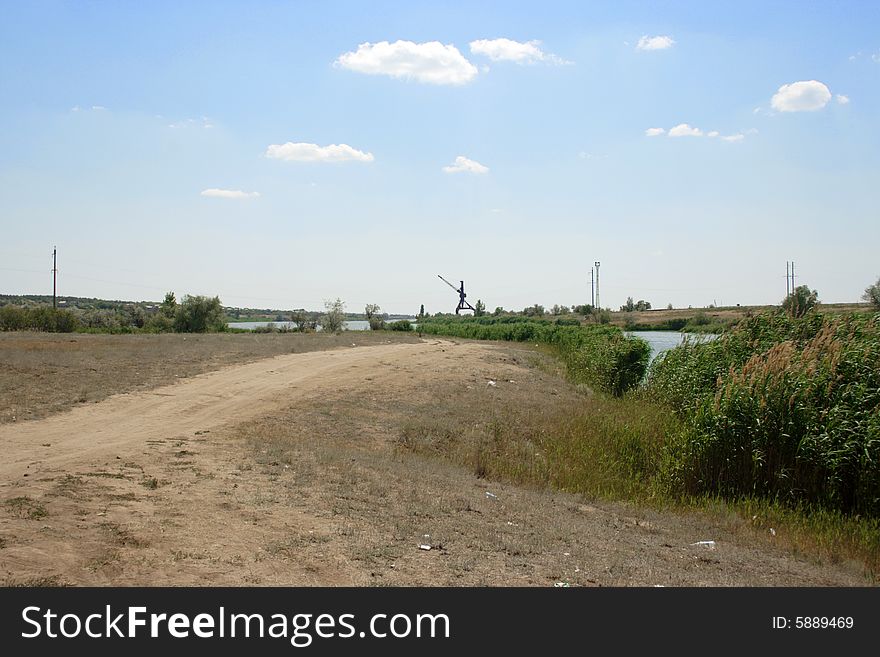 Rural road on background year blue sky and clouds