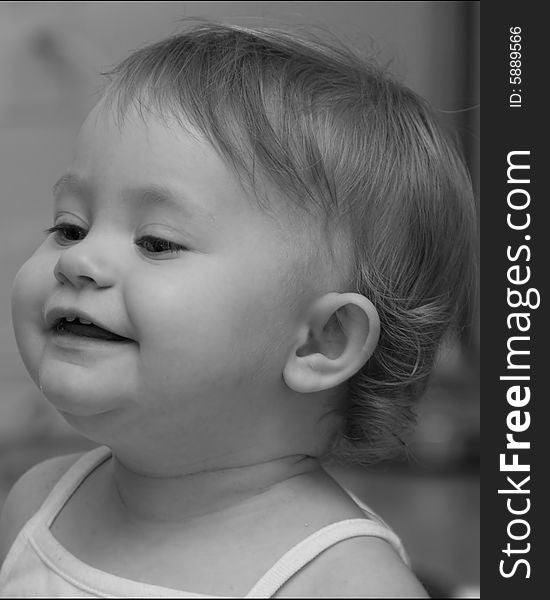 Black and white side portrait of cute baby girl laughing.