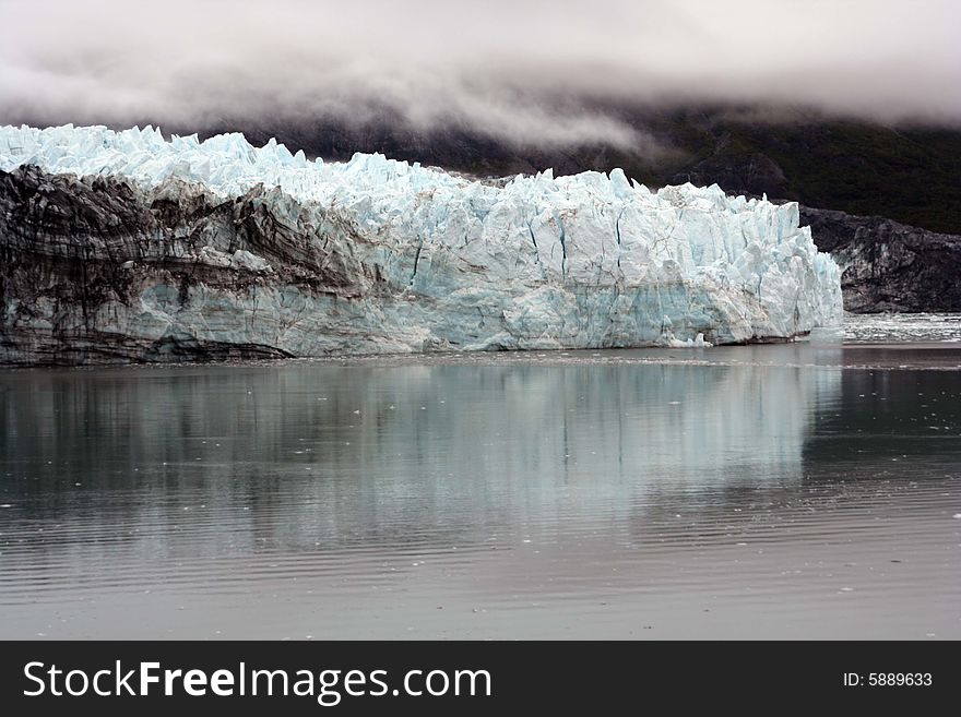 A beautiful blue glacier in Alaska with its reflection in the icy sea. A beautiful blue glacier in Alaska with its reflection in the icy sea.