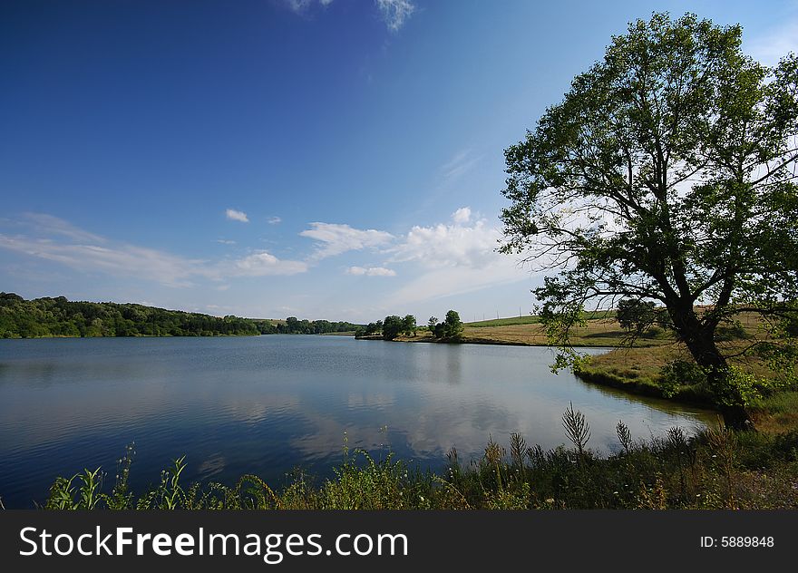 Lake with tree and blue cloudy sky, Bulgaria. Lake with tree and blue cloudy sky, Bulgaria