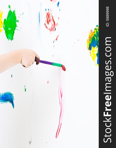 Child painting on the wall with a brush. Child painting on the wall with a brush