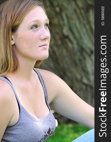 Woman looking up while sitting on the grass. Woman looking up while sitting on the grass