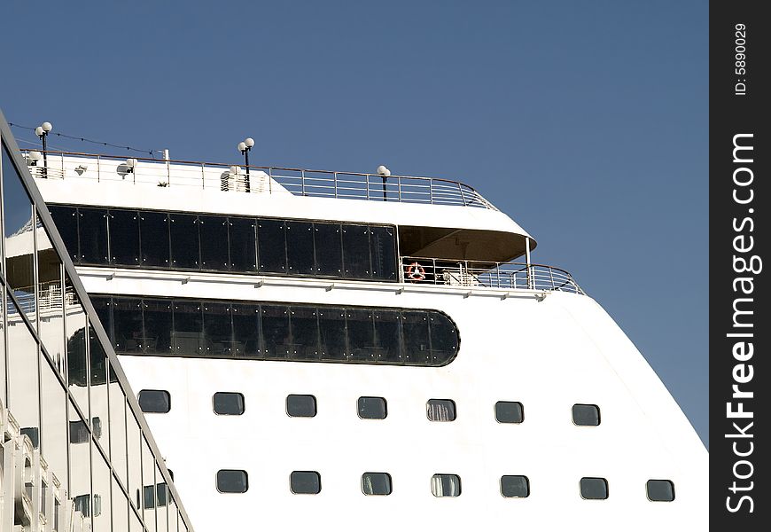 Upper deck of a white cruise liner with cabin windows