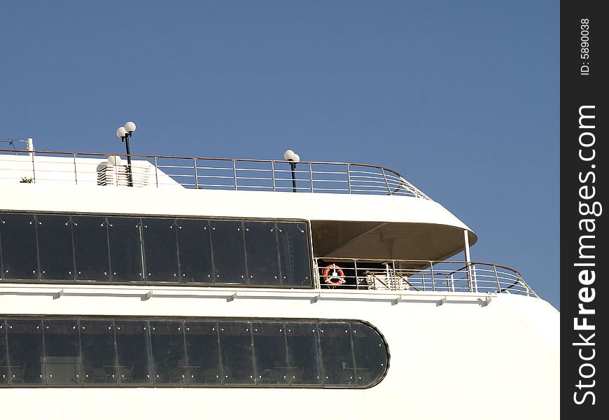 Upper deck of a white cruise liner with cabin windows