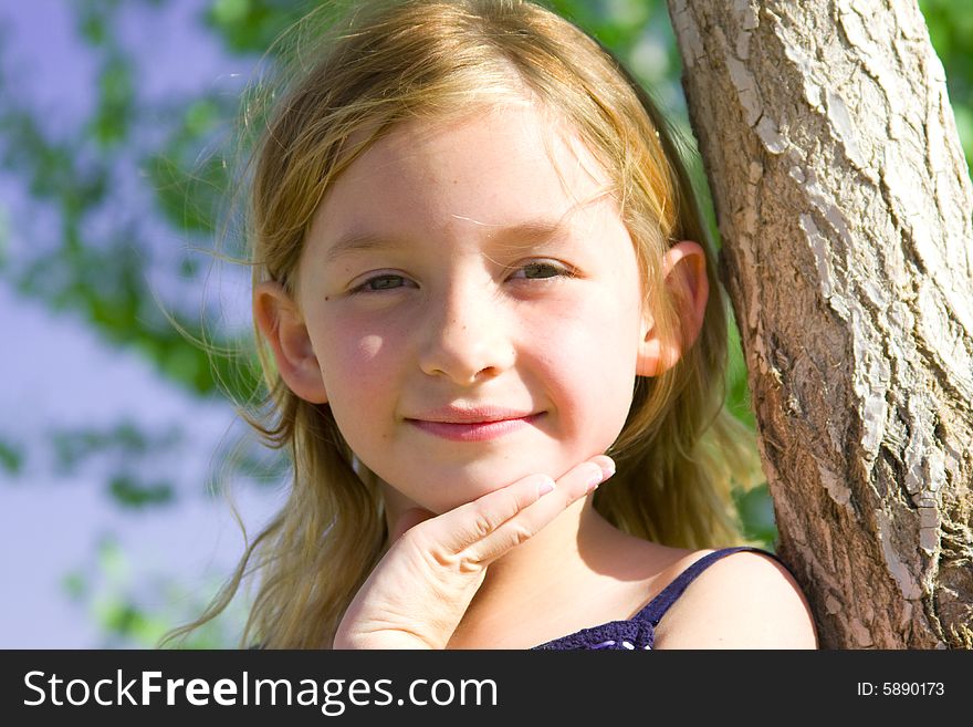 Smiling six year old girl with the sun shining in her hair.