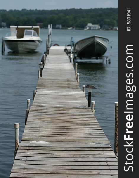 Two boats in dock on a lake. Are they not moving due to high gas prices? Or perhaps this is the ultimate staycation!