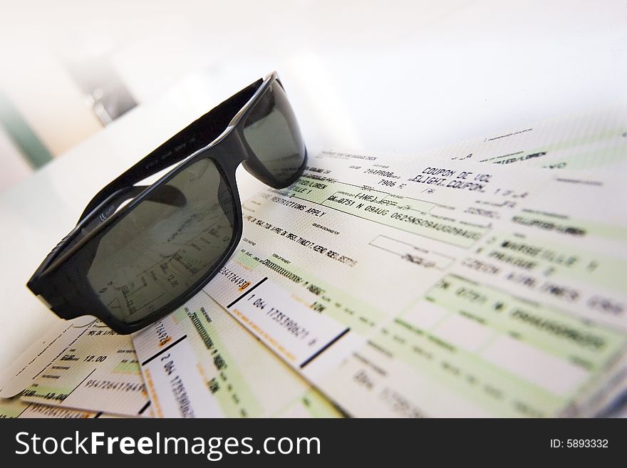 Sunglasses lay down on the flight tickets. Sunglasses lay down on the flight tickets