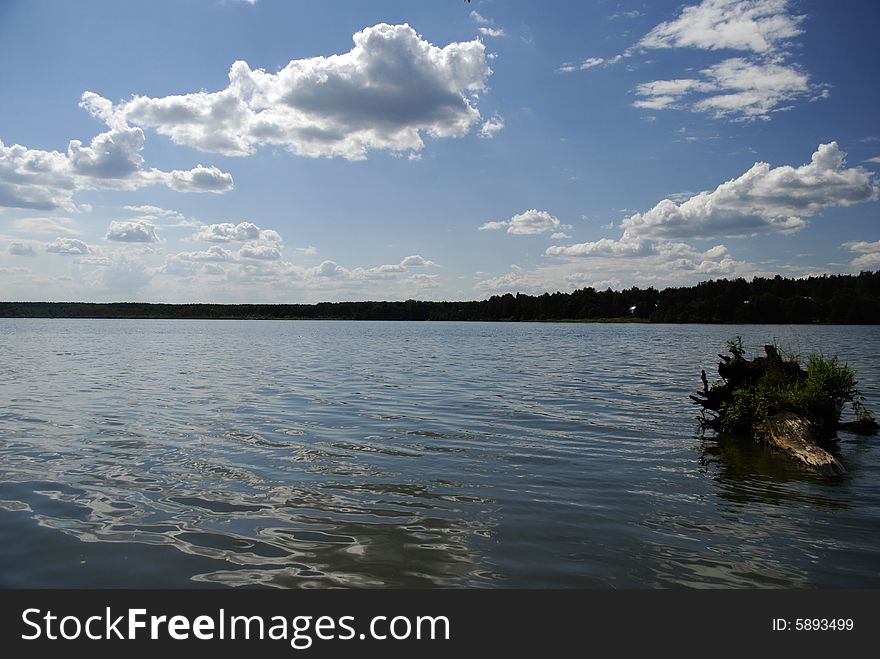 Lake with small waves and blue sky with clouds. Lake with small waves and blue sky with clouds
