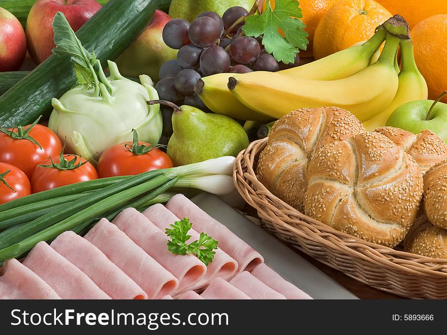 Assortment of vegetables and fruit,  slices of ham and buns. Assortment of vegetables and fruit,  slices of ham and buns