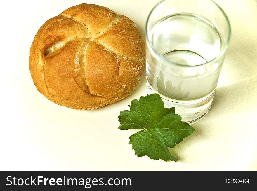 Bread roll and glass of water. Bread roll and glass of water.