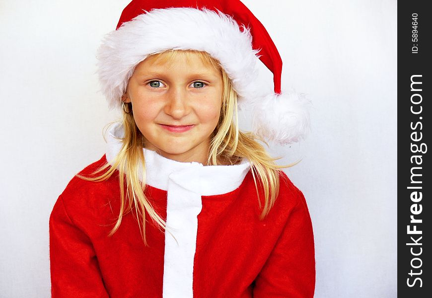 An adorable girl is smiling and wearing a santa hat. An adorable girl is smiling and wearing a santa hat.