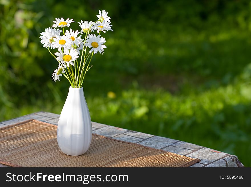 White flowers in white vase on the table