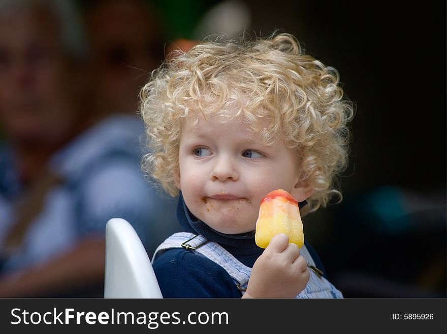 Cute young boy eating ice cream in summer