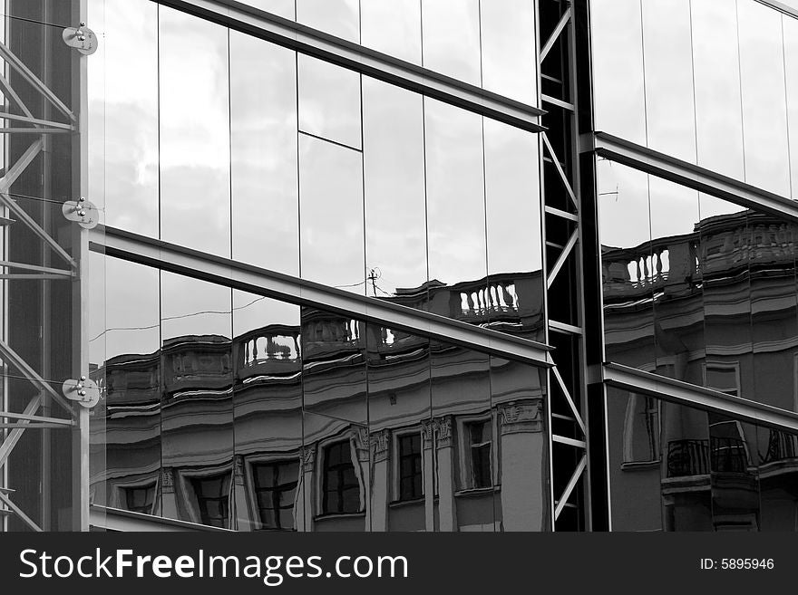 Old house reflected in modern building windows black and white. Old house reflected in modern building windows black and white