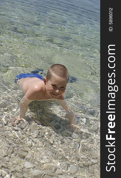 Happy kid playing in water of Adriatic sea