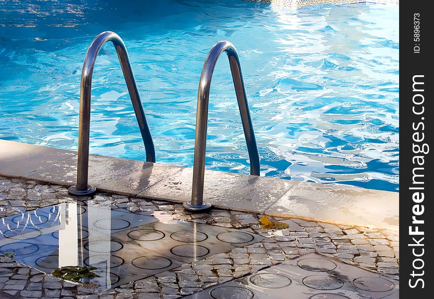 Border of pool and stair, with blue calm water. Border of pool and stair, with blue calm water