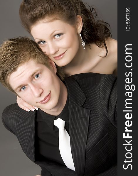 Portrait of a young beautiful couple on gray background