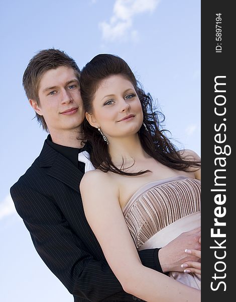 Young beautiful happy couple on sky background